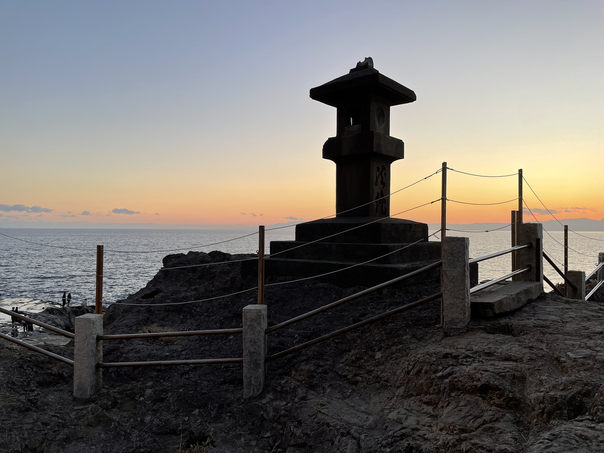 A lamp post with a sunset ocean background